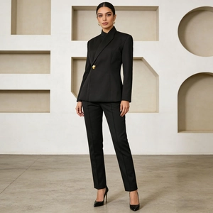 Detail of elegant black blazer set featuring a unique single gold button closure