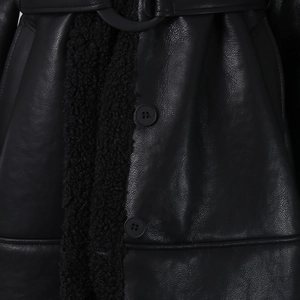 Close-up of black leather coat texture featuring plush faux fur trim and detailed buttons