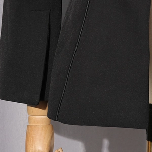 Detail of high-quality black suit fabric with side slit and professional stitching