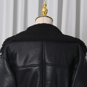 Detail view of the cross-stitched back and shearling collar on this black faux leather coat