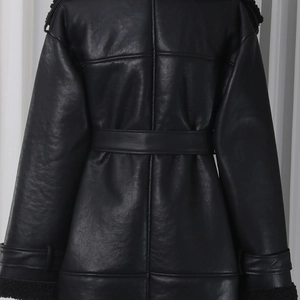Detail of black faux leather trench coat featuring plush shearling collar and waist belt