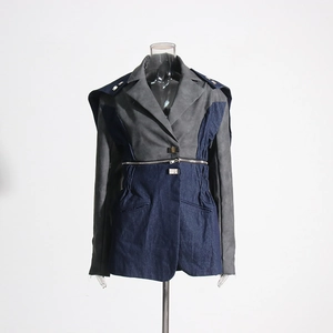 Détail d'une veste en jean bicolore avec fermeture éclair métallique et poches