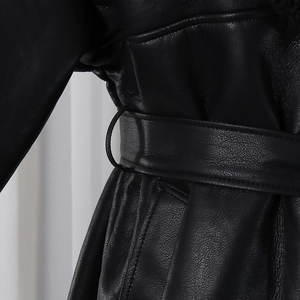 Detail of black leather coat waist belt with metallic buckle and fine stitching