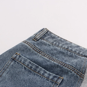 Detail of blue denim waist with contrast stitching and reinforced rear pocket seam