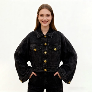 Detail of black washed denim jacket featuring vintage gold buttons and cropped cut