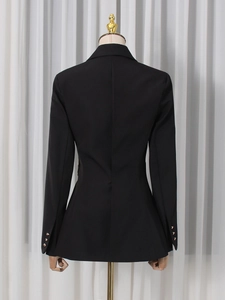 Back view of a tailored black women's blazer with gold buttons on the sleeves