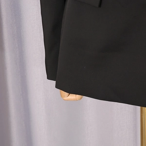 Detail of the high-quality black blazer hem with neat stitching and smooth woven texture