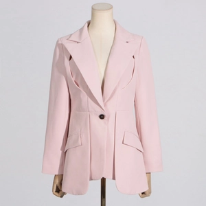 Detail of light pink blazer featuring side cut-outs, single button, and pleated hemline