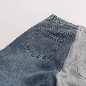 Detail view of denim and grey knit patchwork stitching on casual straight-leg pants