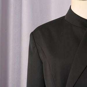 Close-up of the tailored shoulder and lapel detail on a sleek black business blazer
