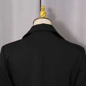 Macro shot of the back collar and seam tailoring of the black minimalist blazer