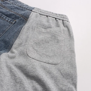 Detail of patchwork denim jeans with elastic waistband and high-quality double stitching