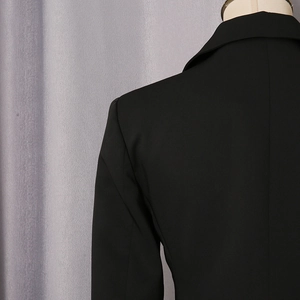 Detail view showing the back shoulder seam and smooth fabric texture of a black blazer