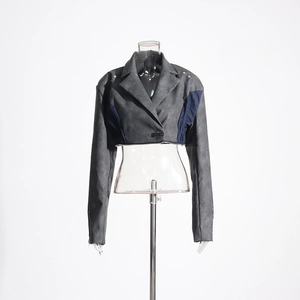 Détail du boléro en daim gris avec empiècements en jean bleu et bords bruts tendance