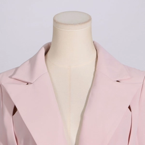 Detailed view of pink blazer lapel with sharp tailoring and textured fabric finish