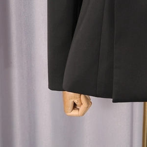 Detail of black blazer cuff and hem showing premium anti-wrinkle fabric texture