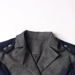 Détail de la veste en jean avec col gris, empiècements aux épaules et clous carrés argentés