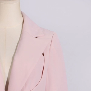 Detailed close-up of pink blazer notched lapel and shoulder seam on a mannequin