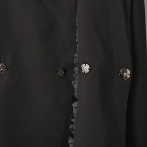 Close-up of black blazer fabric texture featuring buttons with silver metallic accents