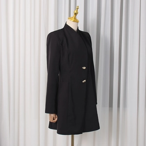 Détail de la robe blazer noire avec col officier et boutons dorés à la taille