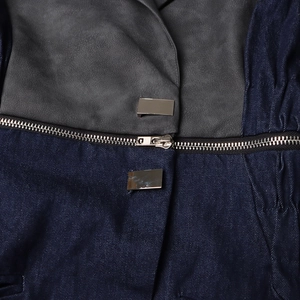 Détail du patchwork en denim et cuir avec fermeture éclair et attaches en métal argenté