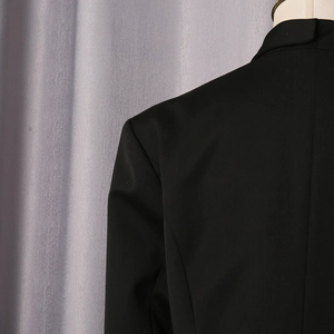 Close-up of the shoulder tailoring and clean stitching on a black tailored blazer jacket