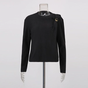 Détail d'un haut noir à manches longues avec boucle dorée à l'épaule et design froncé