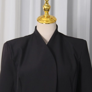 Détail d'une robe blazer noire de style français avec col montant sur un mannequin