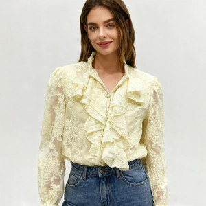 Vue détaillée d'une chemise en dentelle jaune avec col à volants et manches bouffantes