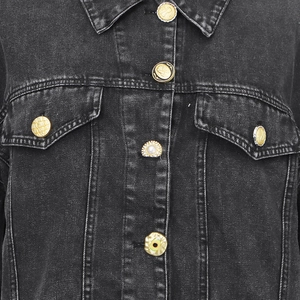 Detailed macro shot of vintage metal buttons and washed denim fabric on black jacket