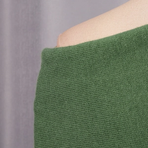Close-up detail of the vibrant green ribbed knit fabric on a stylish shoulder sweater