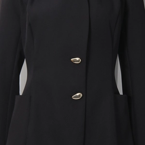 Détail de boutons dorés en forme de larme sur un blazer noir cintré de haute qualité