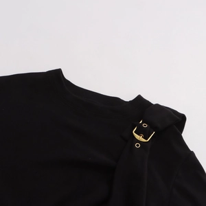 Détail du t-shirt noir avec bandoulière décorative et boucle métallique dorée