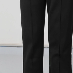 Detailed macro view of black trousers featuring sharp center crease and premium fabric texture