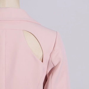 Detail of light pink blazer showing unique teardrop shoulder cutout and twill fabric texture