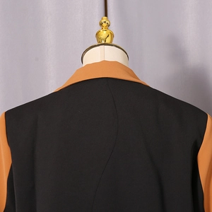 Detail view of the back seams and color-block design on the tailored suit jacket
