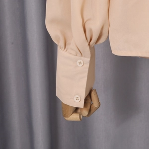 Detail of light pink shirt cuff with double buttons and delicate sleeve pleats