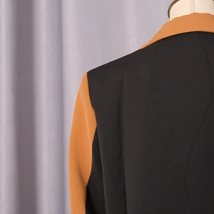 Detail of color-block blazer showing premium stitching on the shoulder and collar
