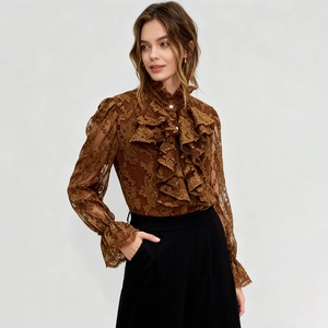 Détail du chemisier en dentelle marron avec volants, manches bouffantes et pantalon taille haute