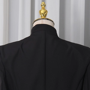 Détail de l'encolure et des coutures d'épaule d'une robe blazer noire à manches longues