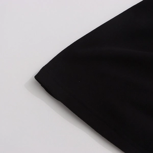 Détail du poignet du T-shirt noir avec coutures premium sur tissu en coton doux