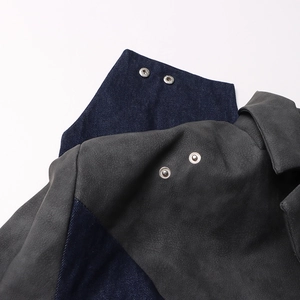 Détail de la veste en jean et daim gris avec boutons-pression en métal argenté