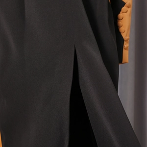 Detail of black blazer featuring contrasting brown cuffs with decorative buttons