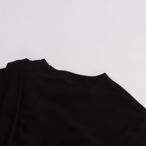 Gros plan du col rond et des coutures soignées sur ce t-shirt noir minimaliste