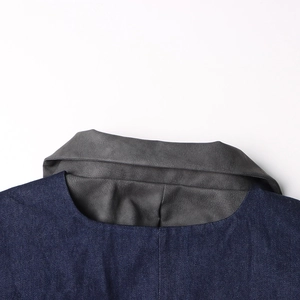 Détail du col d'une veste en jean bleu foncé avec empiècement en daim gris contrasté