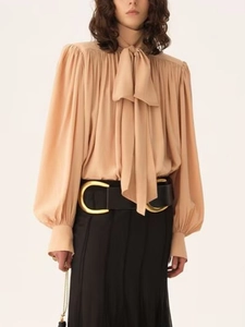 Elegant apricot satin long-sleeved blouse with bow-tie neck and pleated puff sleeves
