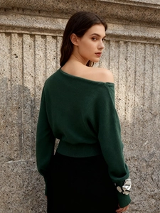 Elegant deep green off-shoulder knit sweater with a slim silhouette and ribbed waist detail