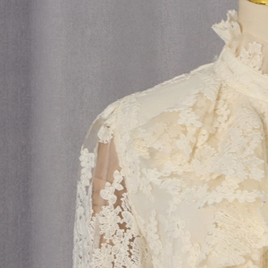 Détail du col en dentelle élégante et broderie florale sur un chemisier crème chic