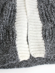 Long knit cardigan in dark grey and cream white with textured cable knit patterns