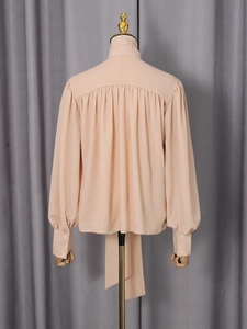 Elegant apricot chiffon long sleeve blouse featuring pleats and a stylish tie-back collar